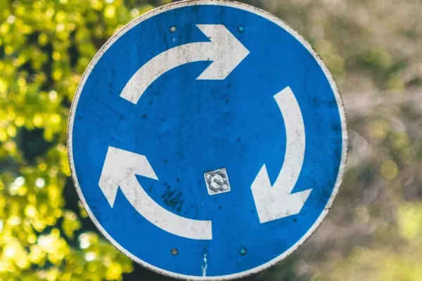 Ein rundes Schild mit weißen Pfeilen auf blauem Hintergrund 